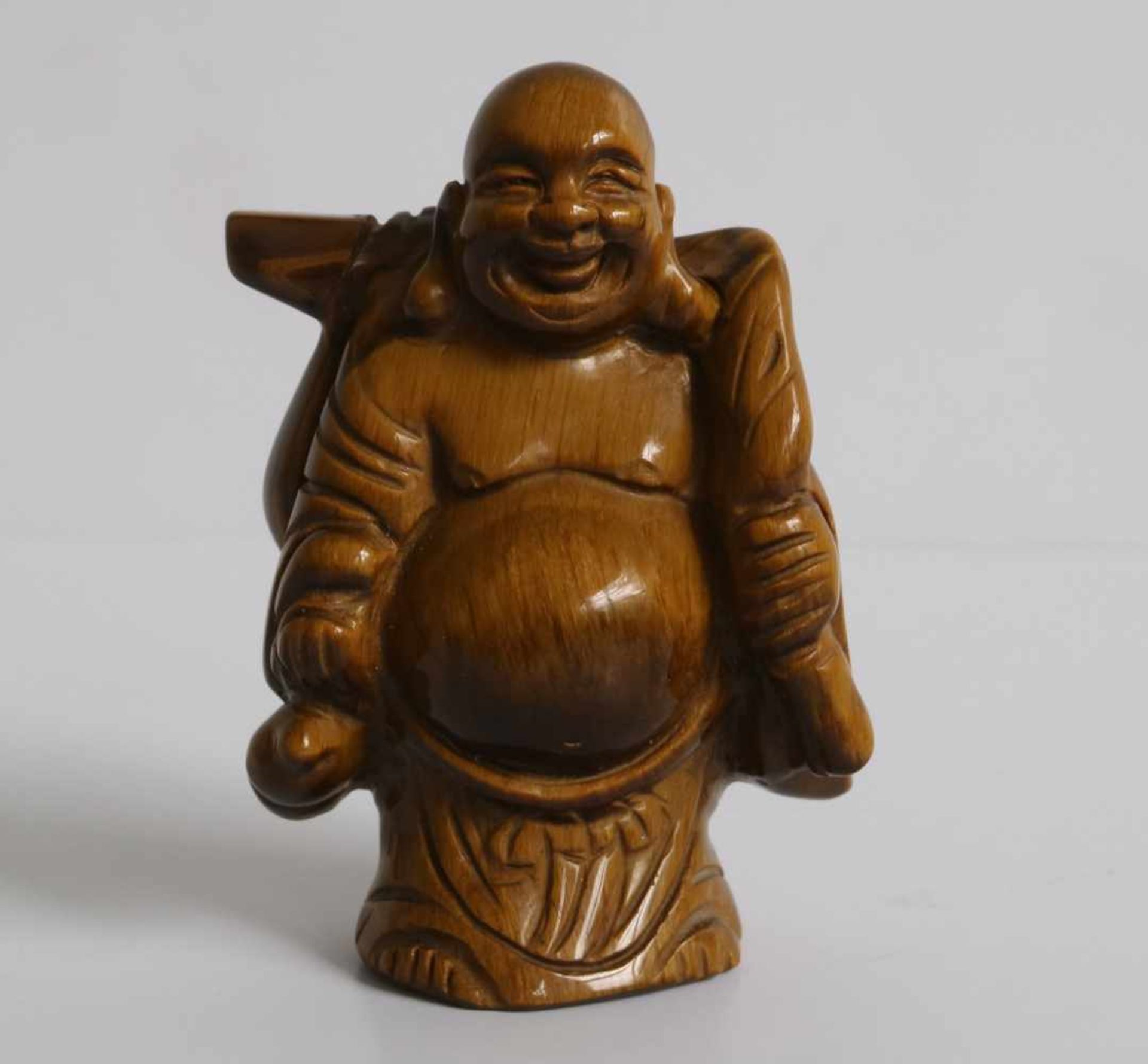 Netsuke Tiger's eye Ivory figure of a Hotei, carrying a gourd and knapsack Japan early 20th century