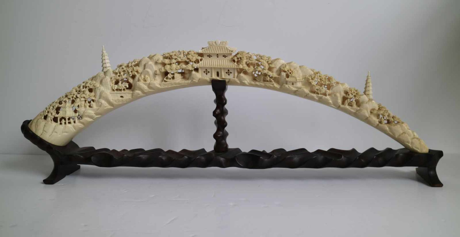 A carved ivory tusk Depicting village scenes with pagodas Canton China ca 1930 L 61 cm