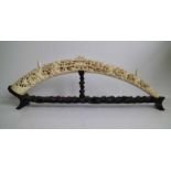 A carved ivory tusk Depicting village scenes with pagodas Canton China ca 1930 L 61 cm