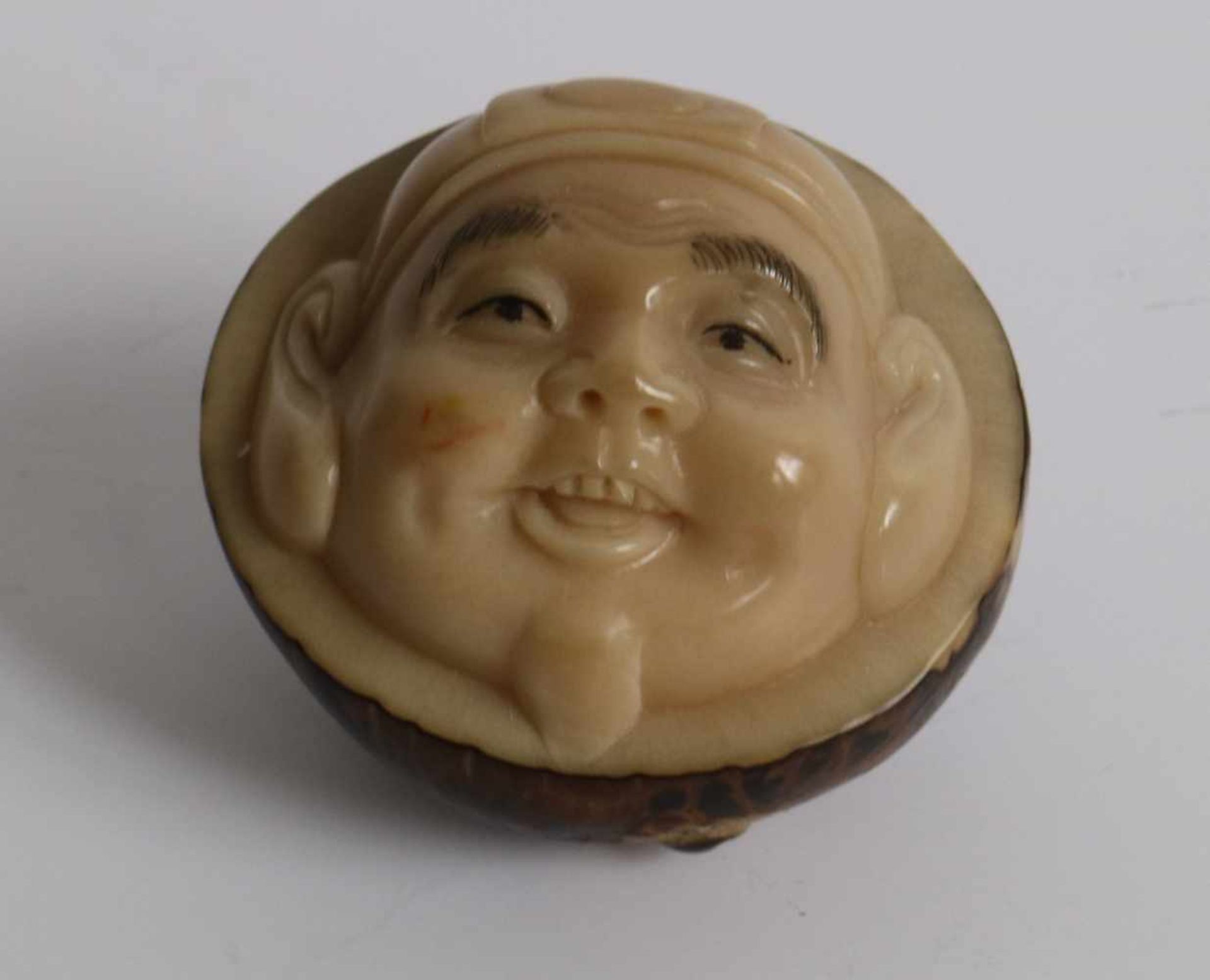 Carved netsuke depicting a Hotei, Made of tagua nut Japan 20th century L 4,2 cm private collection