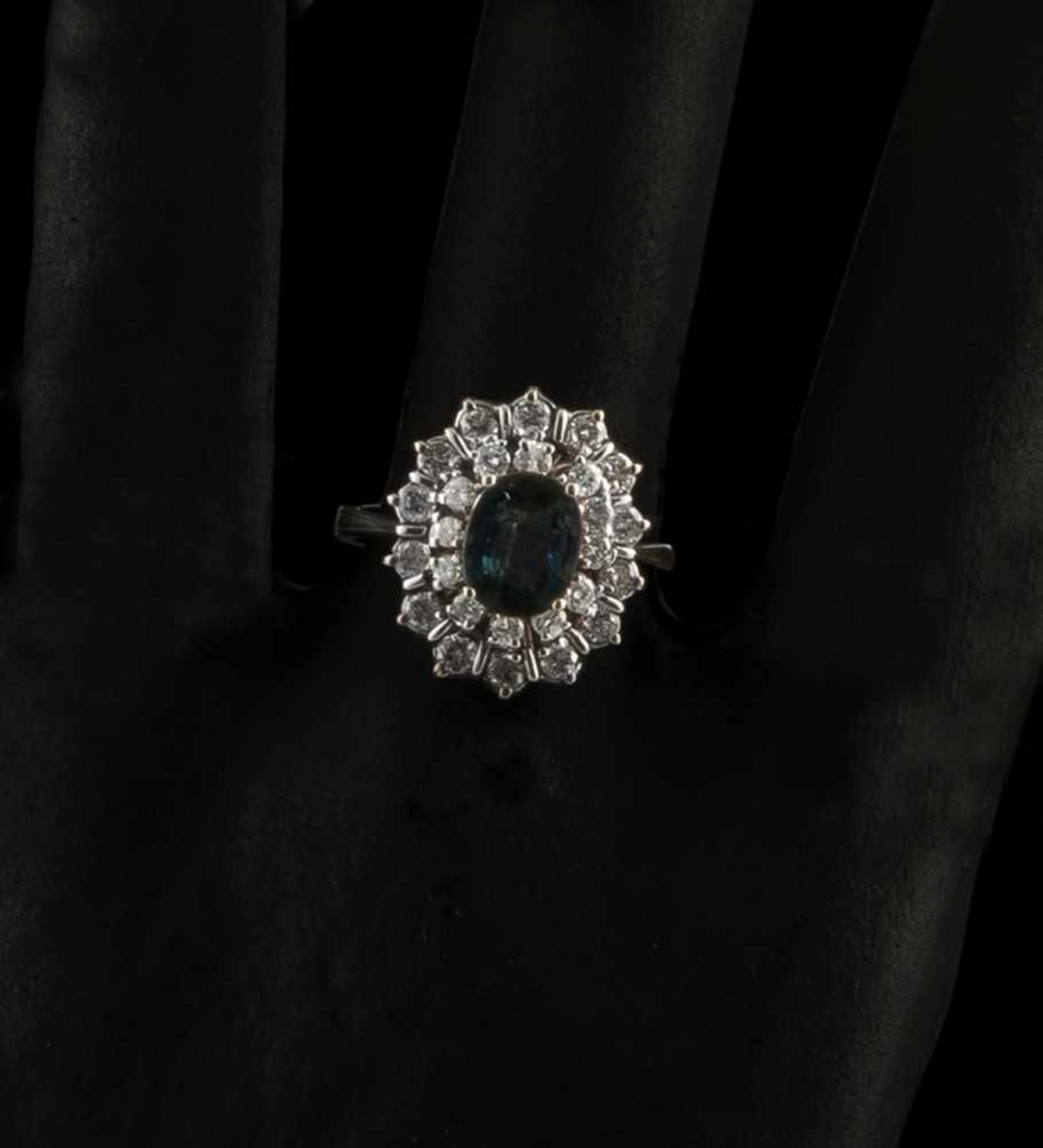A SAPPHIRE AND DIAMOND RING, 1960ies. 585 white gold, oval cut sapphire c. 2 ct., 26 diamonds tog.c.