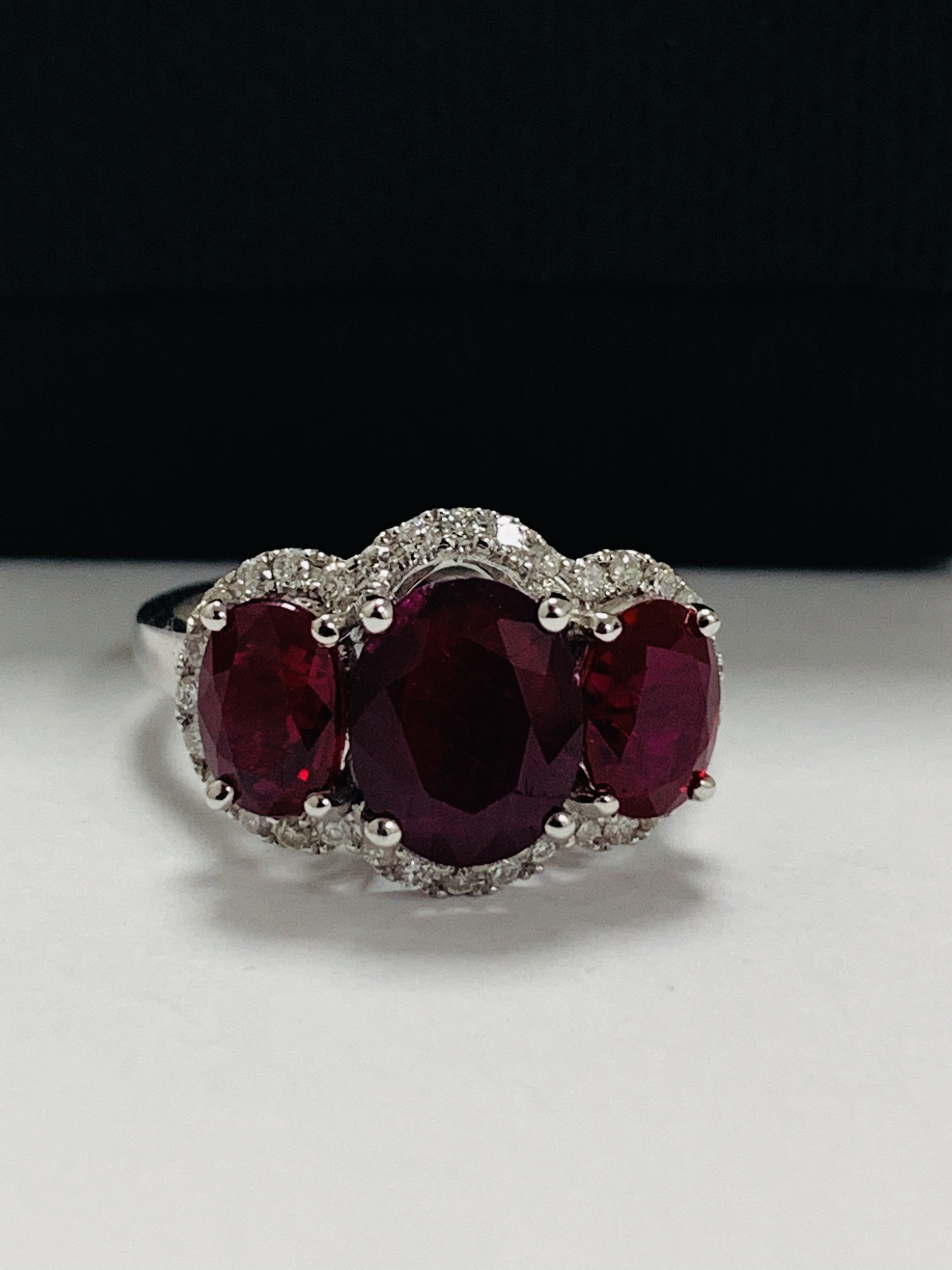 14ct White Gold Ruby and Diamond ring featuring centre, oval cut Ruby (1.67ct), claw set, with 2 ova - Image 9 of 12