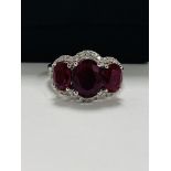 14ct White Gold Ruby and Diamond ring featuring centre, oval cut Ruby (1.67ct), claw set, with 2 ova