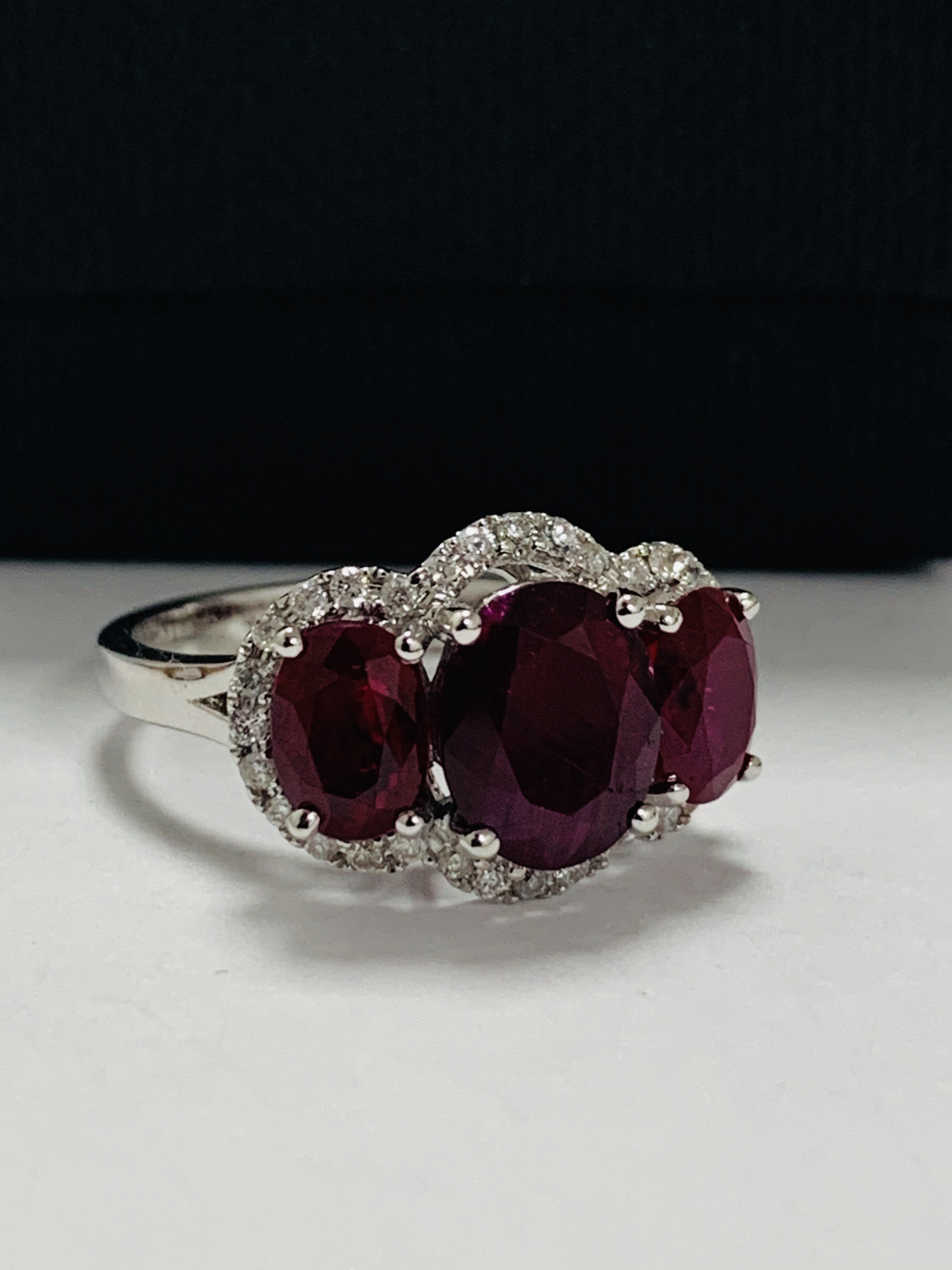 14ct White Gold Ruby and Diamond ring featuring centre, oval cut Ruby (1.67ct), claw set, with 2 ova - Image 8 of 12