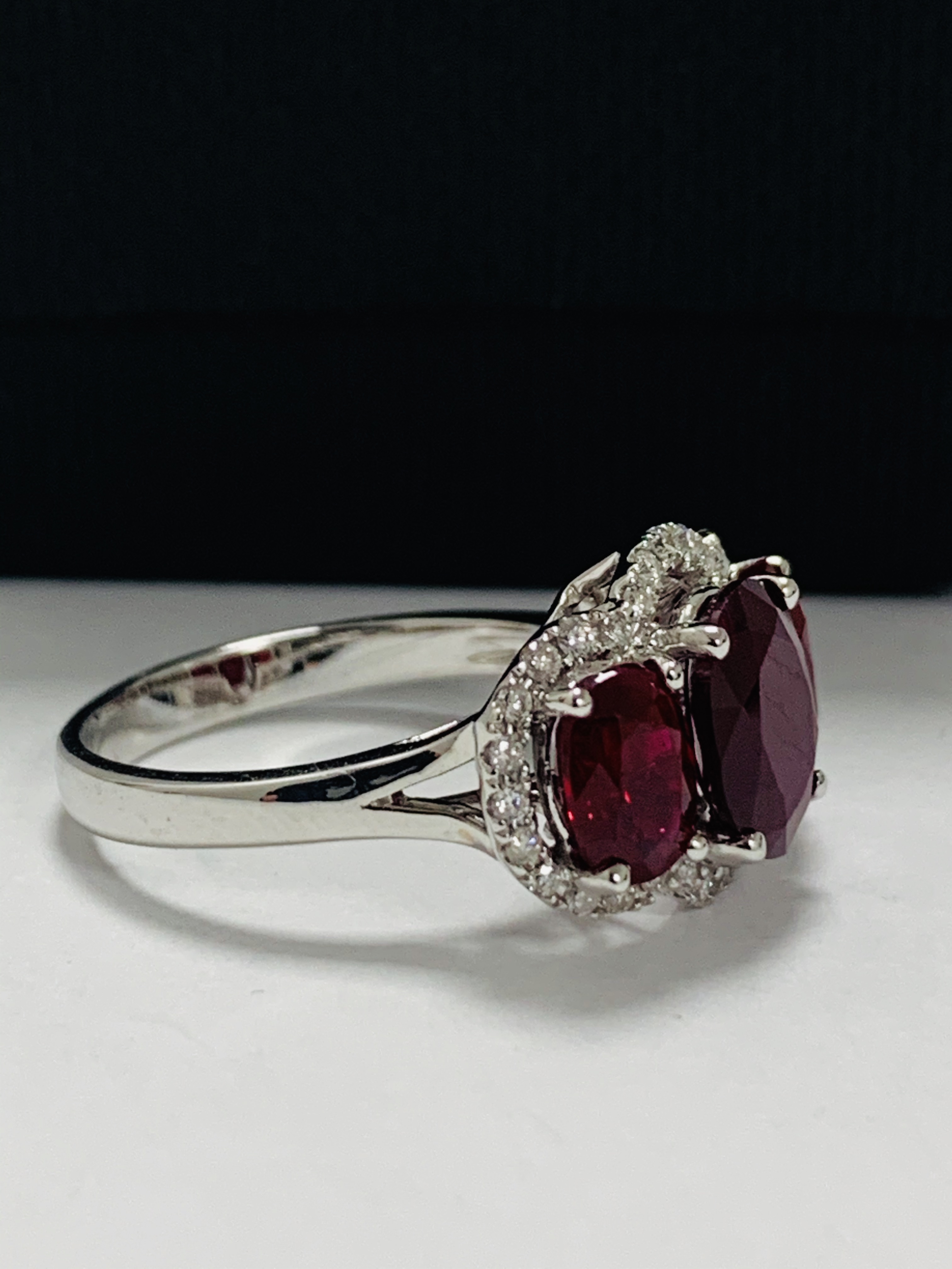 14ct White Gold Ruby and Diamond ring featuring centre, oval cut Ruby (1.67ct), claw set, with 2 ova - Image 7 of 12