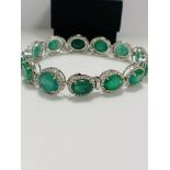 Platinum and Yellow Gold Emerald and Diamond bracelet featuring, 13 oval cut, medium to deep green E