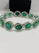 Platinum and Yellow Gold Emerald and Diamond bracelet featuring, 13 oval cut, medium to deep green E