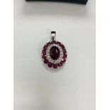 14ct White Gold Ruby and Diamond pendant featuring centre, oval cut, vivid red Ruby, claw set, with