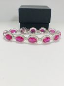 Platinum Ruby and Diamond bracelet featuring, 12 oval cut, pinkish red Rubies (15.19ct TSW), claw se