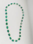 Platinum and Yellow Gold Emerald and Diamond necklace featuring, 29 oval cut, light to deep green Em