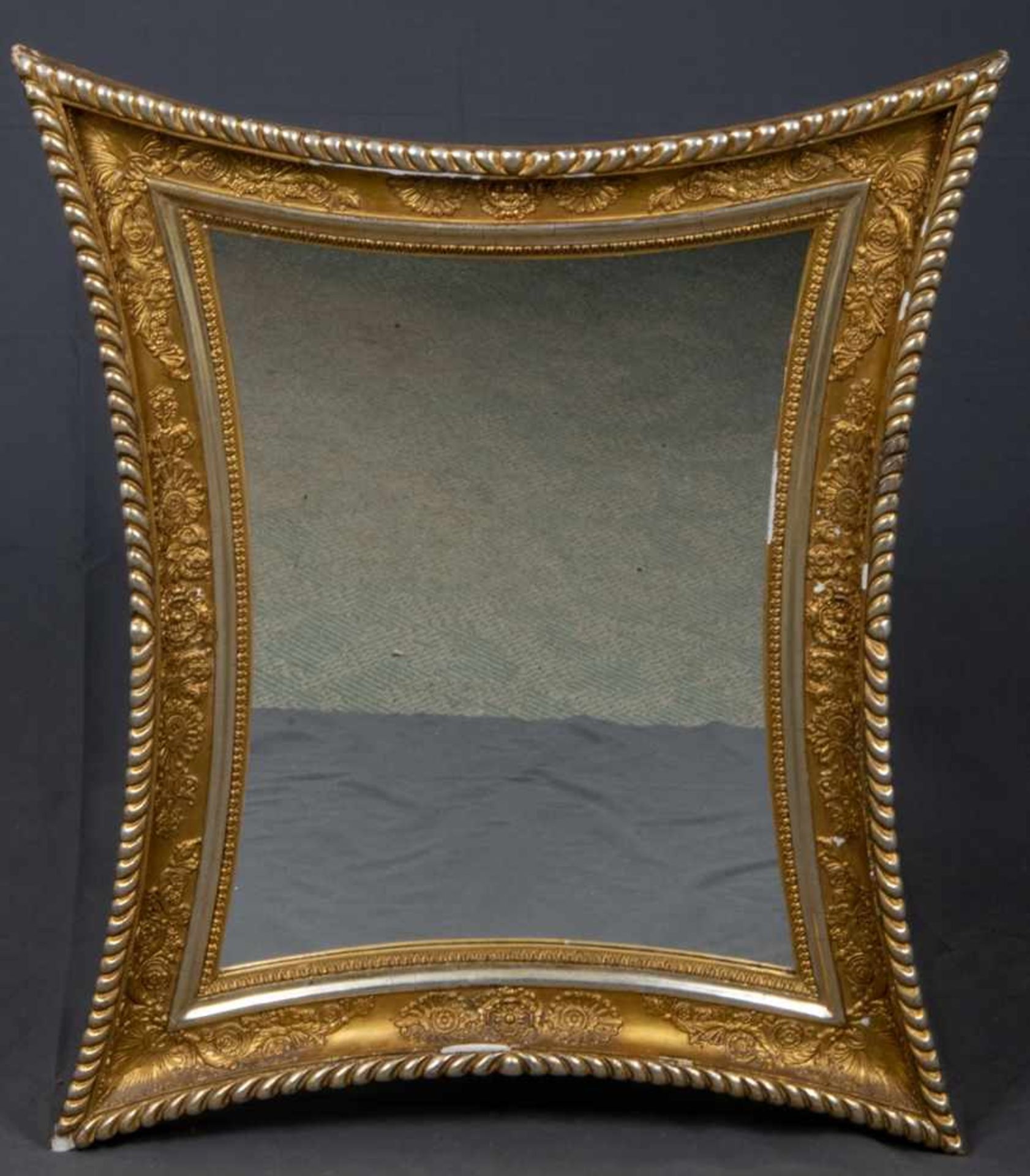 Äußerst eleganter Empirespiegel um 1800/20. Allseitig konkav geschwungener Rahmen mit
