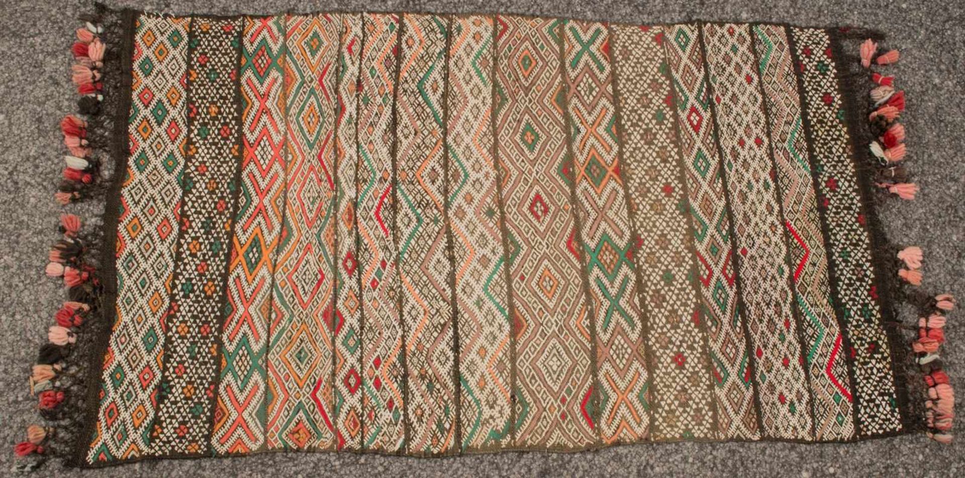 Kelim - Decke, ca. 117 x 70 cm. Dekor aus 15 versch., nebeneinander angeordneten Bordüren. Schöner