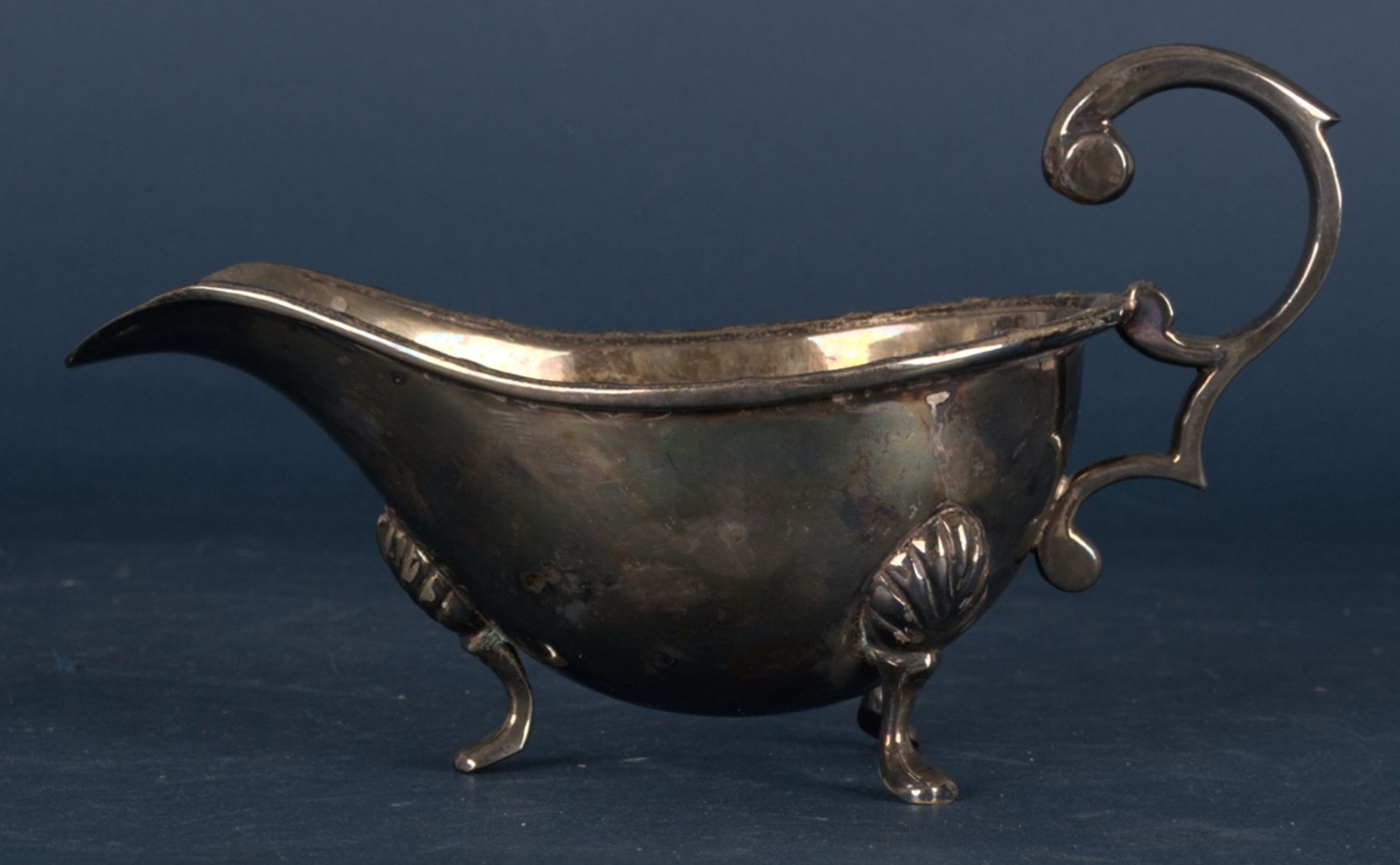 Schwere Henkelsauciere. Versilberter Metallkorpus, Länge ca. 19 cm. Schöner, gebrauchter Erhalt.