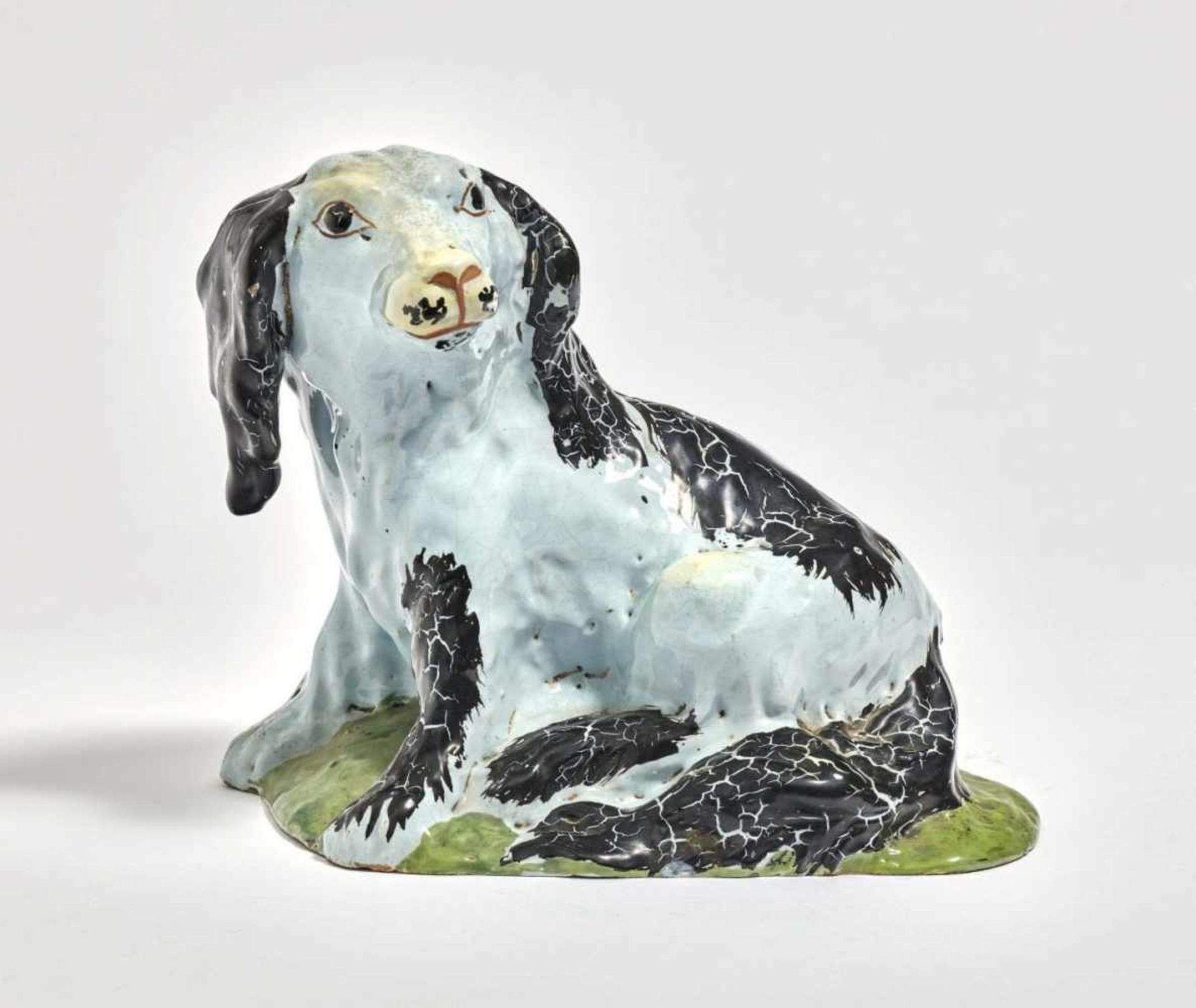 Sitzender HundWohl Brüssel, 18. Jh. Fayence. Weiße Glasur, schwarz und grün staffiert, partiell
