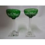 Stevens and Williams - a pair of green overlay glass cocktail coupes, the green bowls cut through to