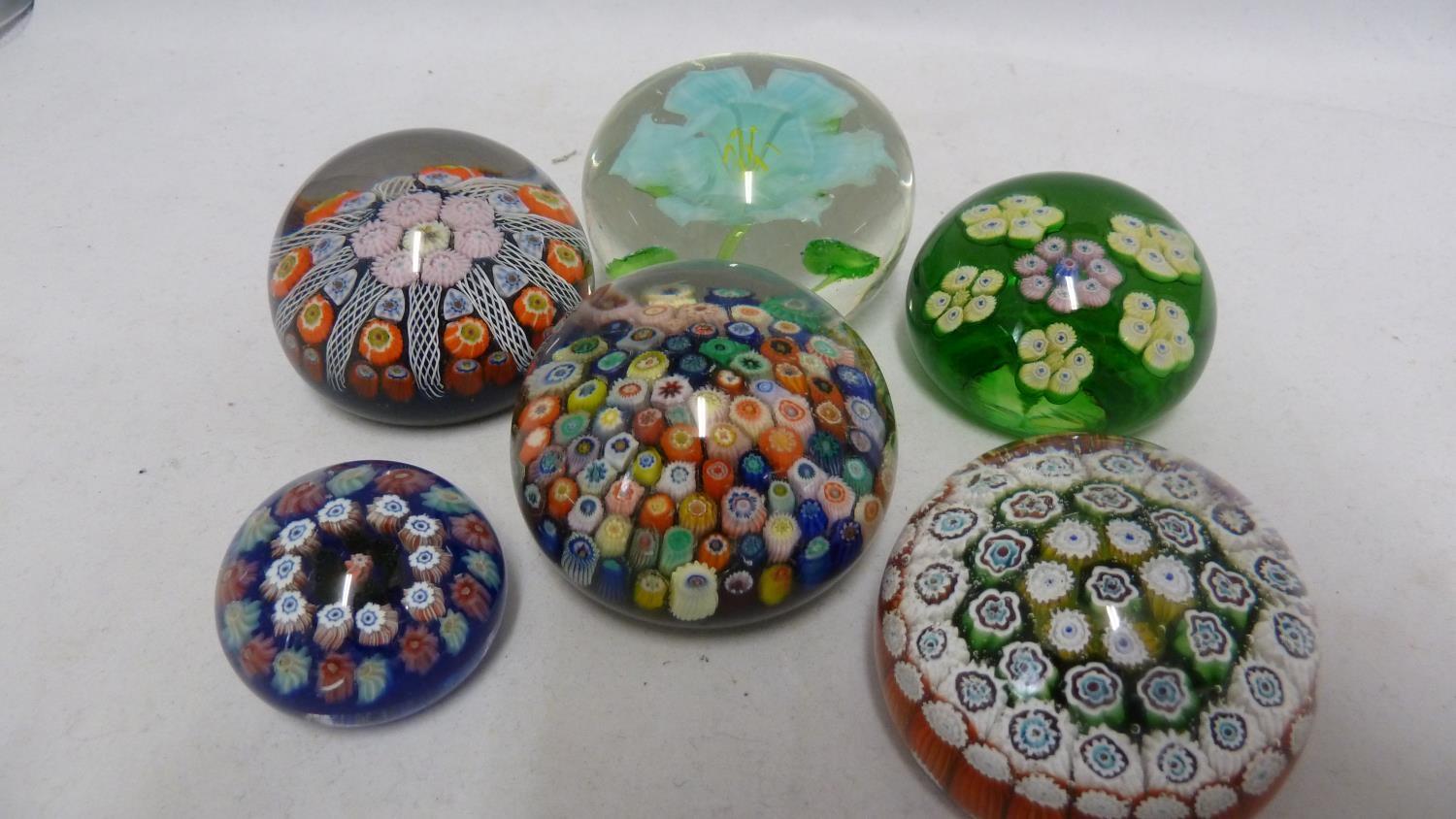 Paperweights - five millifiore decorated glass paper weights; and one enclosing a flower (6)