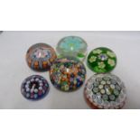 Paperweights - five millifiore decorated glass paper weights; and one enclosing a flower (6)