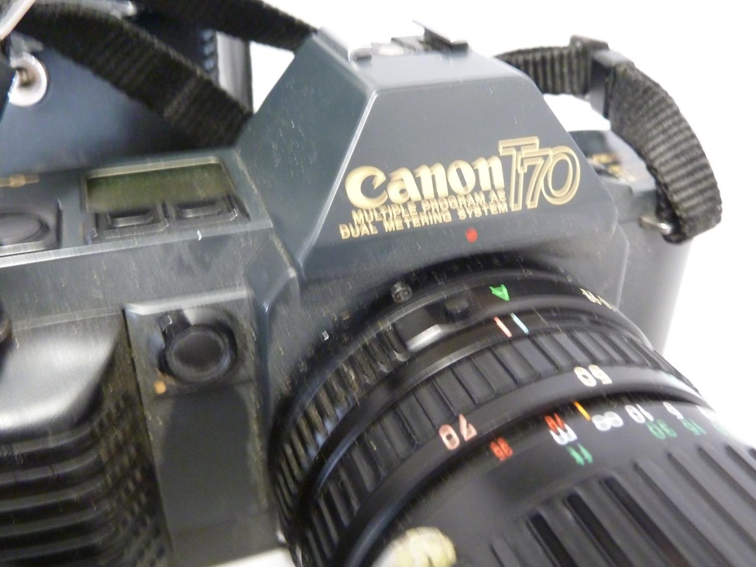 A Canon t70 camera body; a cannon Zoom Lens FD 35-70mm 1:3.6-4.5 with papers; and a Canon Speedlite - Image 4 of 5