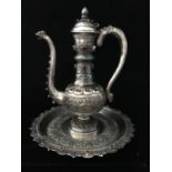An Persian silver ewer and tray, the ewer of bottle form body with sinous handle and spout bothe
