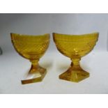 Bohemian Glass - A pair of amber glass boat form pedestal salts, cut with hobnail banding and dentil