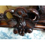 A French mahogany veneered carved wood headboard, decorated with a fruiting vine, upholstered