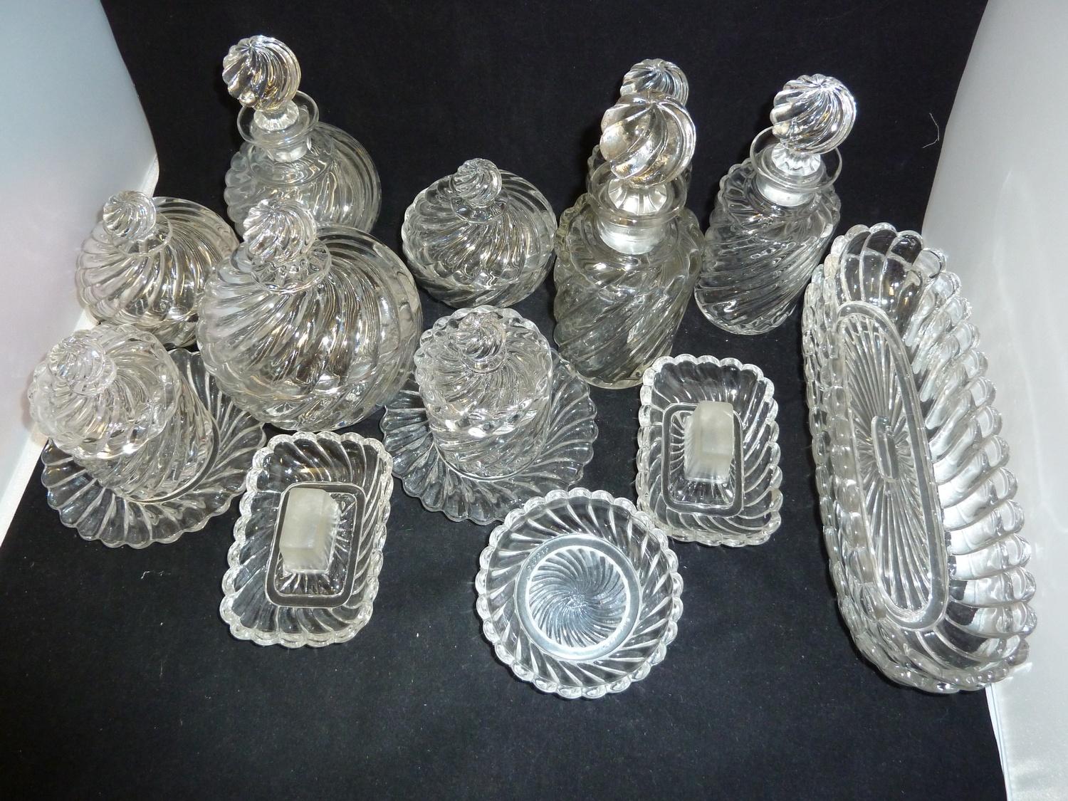 A Baccarat glass dressing table service, colourless, decorated with wrythen gadrooning, comprises,