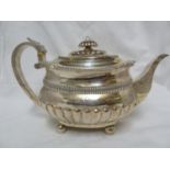 A silver teapot, the gadrooned and fluted body with silver handle and knop, marks worn, 656 grams