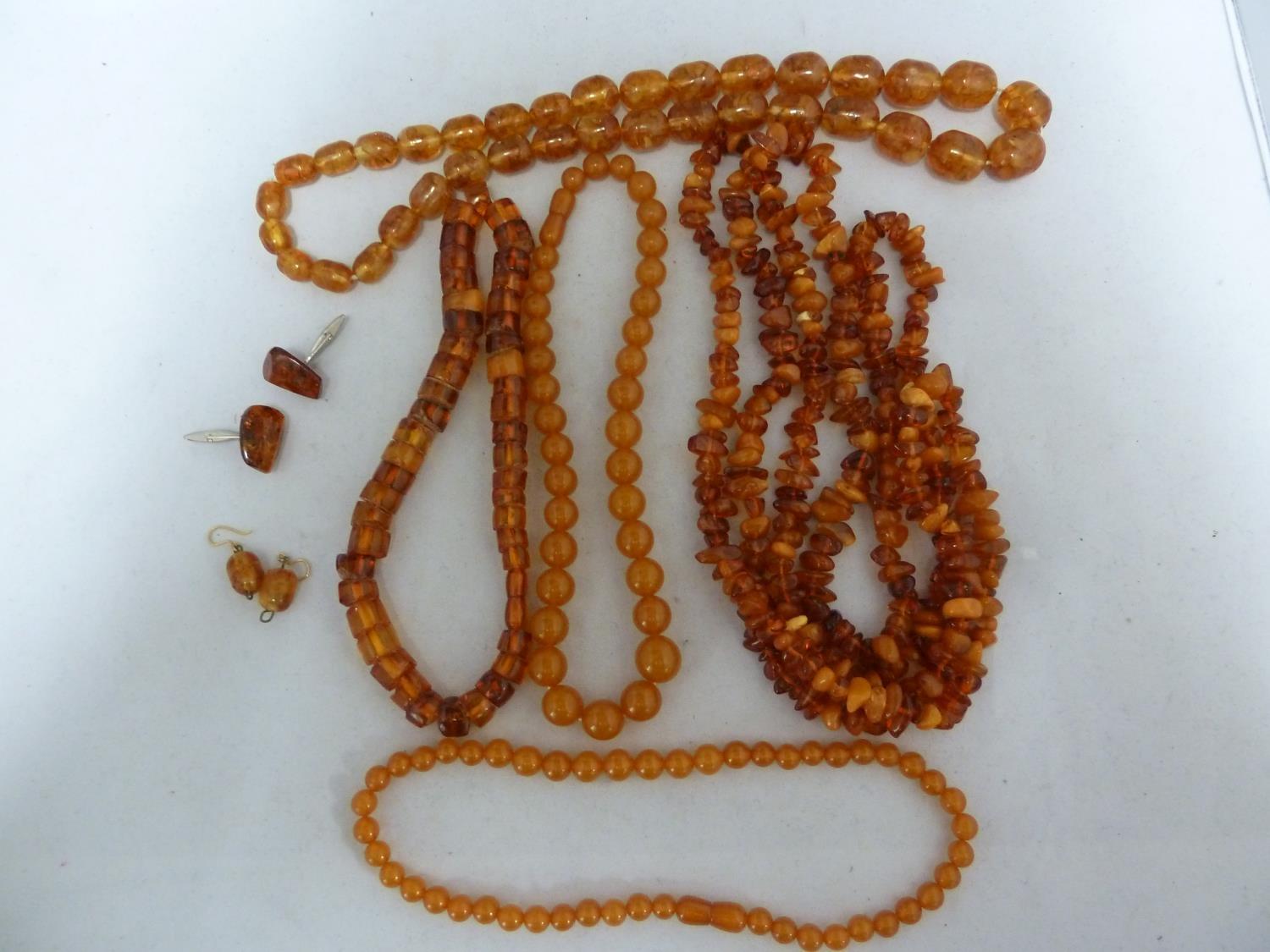 Various items of amber set jewellery comprising: two graduated round bead necklaces with screw