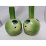 A pair of Ault bottle vases, decorated with blue pansy flowers on a graduated green ground,