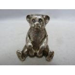 A rare Teddy Bear form silver pin cushion, modelled seated, a velvet covered pad inset into his