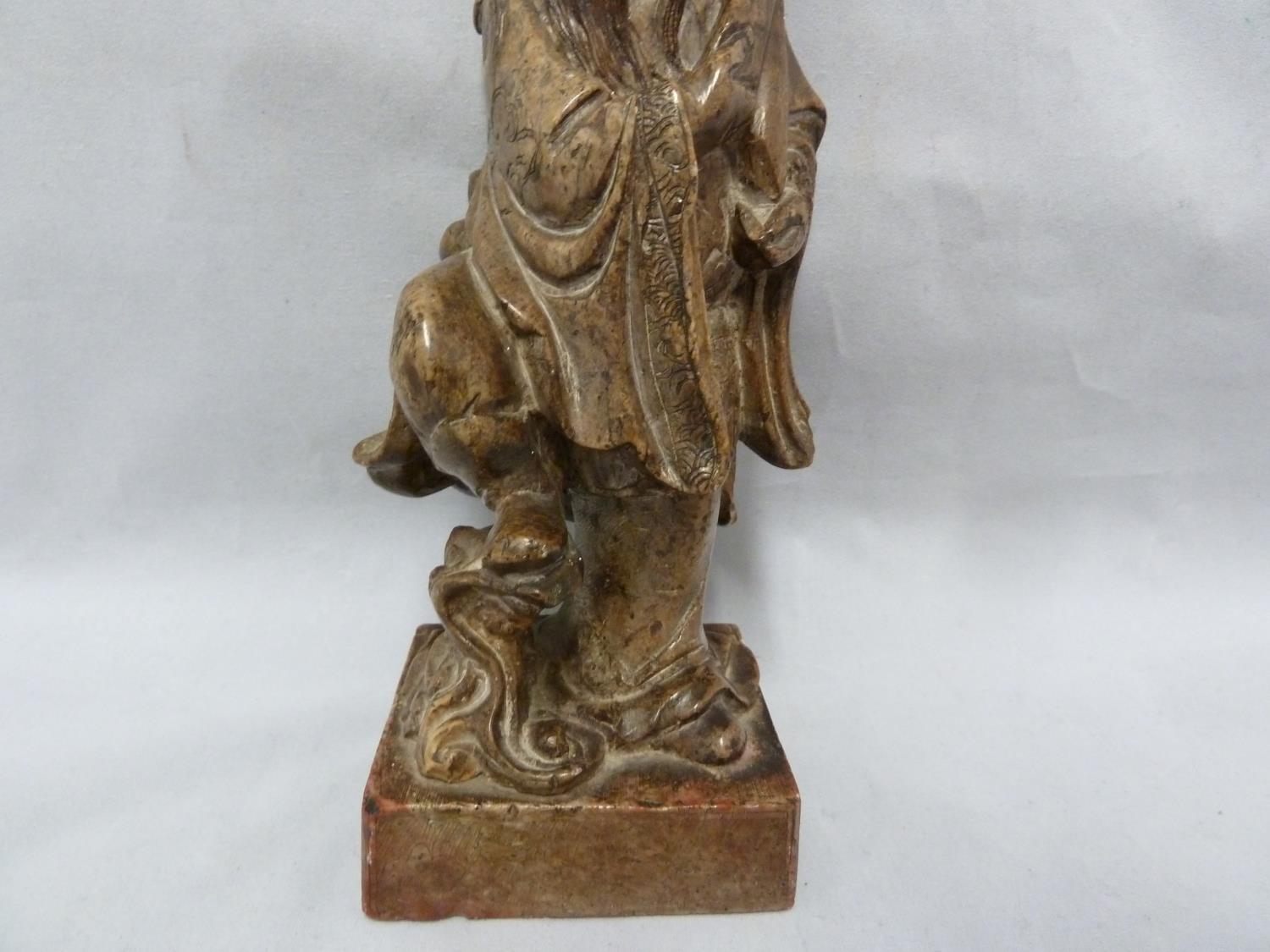 A Chinese carved soapstone figure of an immortal, modelled standing with sceptre and one foot raised - Image 3 of 6