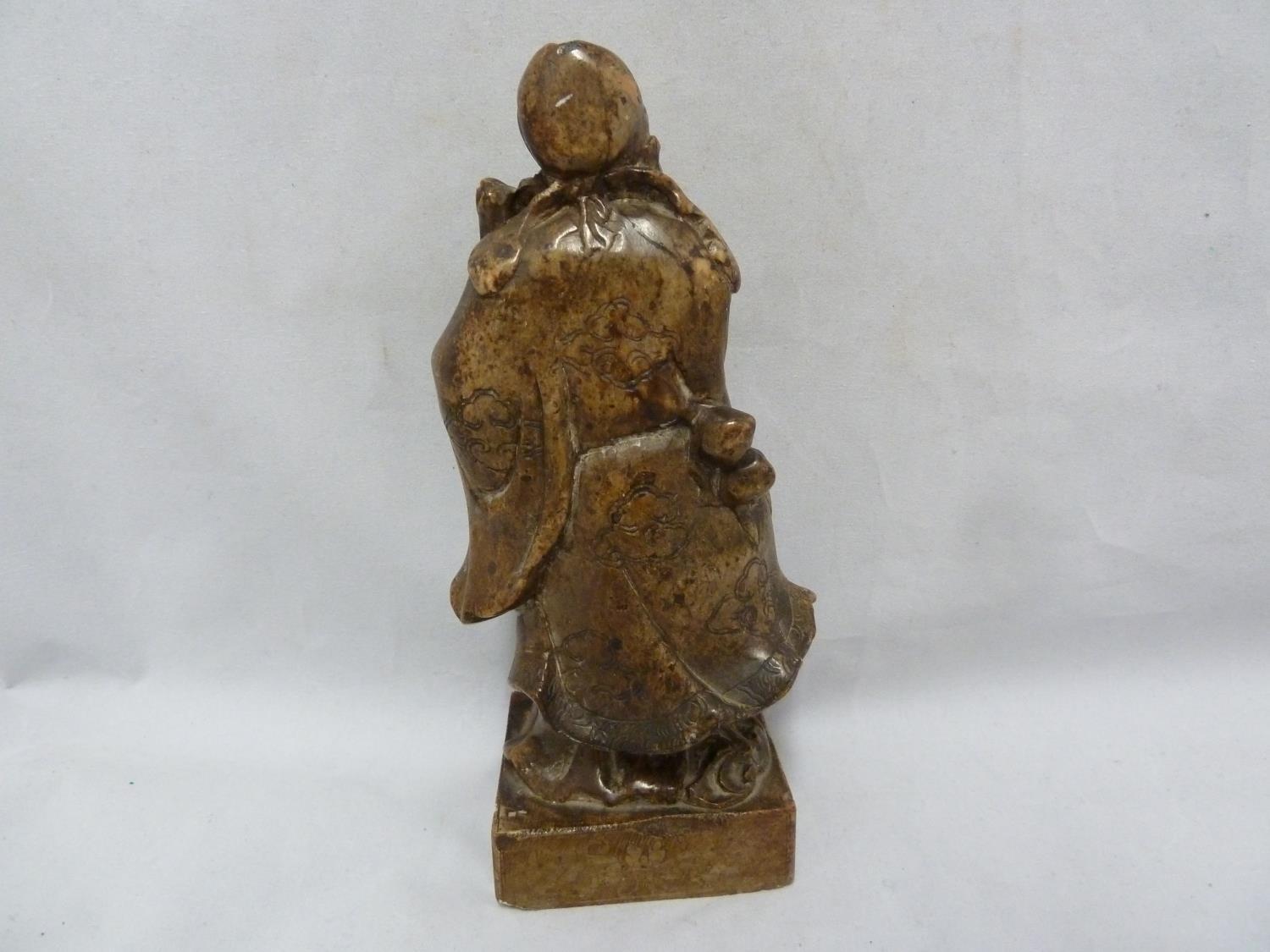 A Chinese carved soapstone figure of an immortal, modelled standing with sceptre and one foot raised - Image 5 of 6