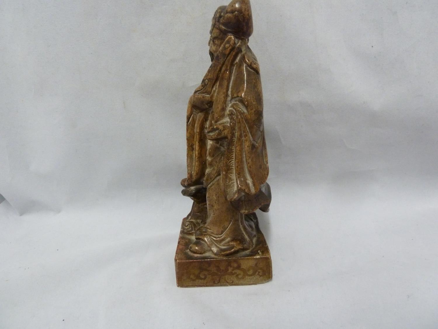 A Chinese carved soapstone figure of an immortal, modelled standing with sceptre and one foot raised - Image 4 of 6