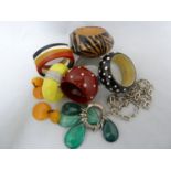 A group of vintage plastic bangles, including a rhinestone spotted example on cherry red plastic;