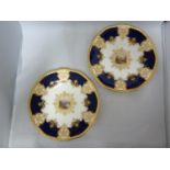 Two Coalport porcelain cabinet plates, decorated with a shaped square vignette of riverscapes within