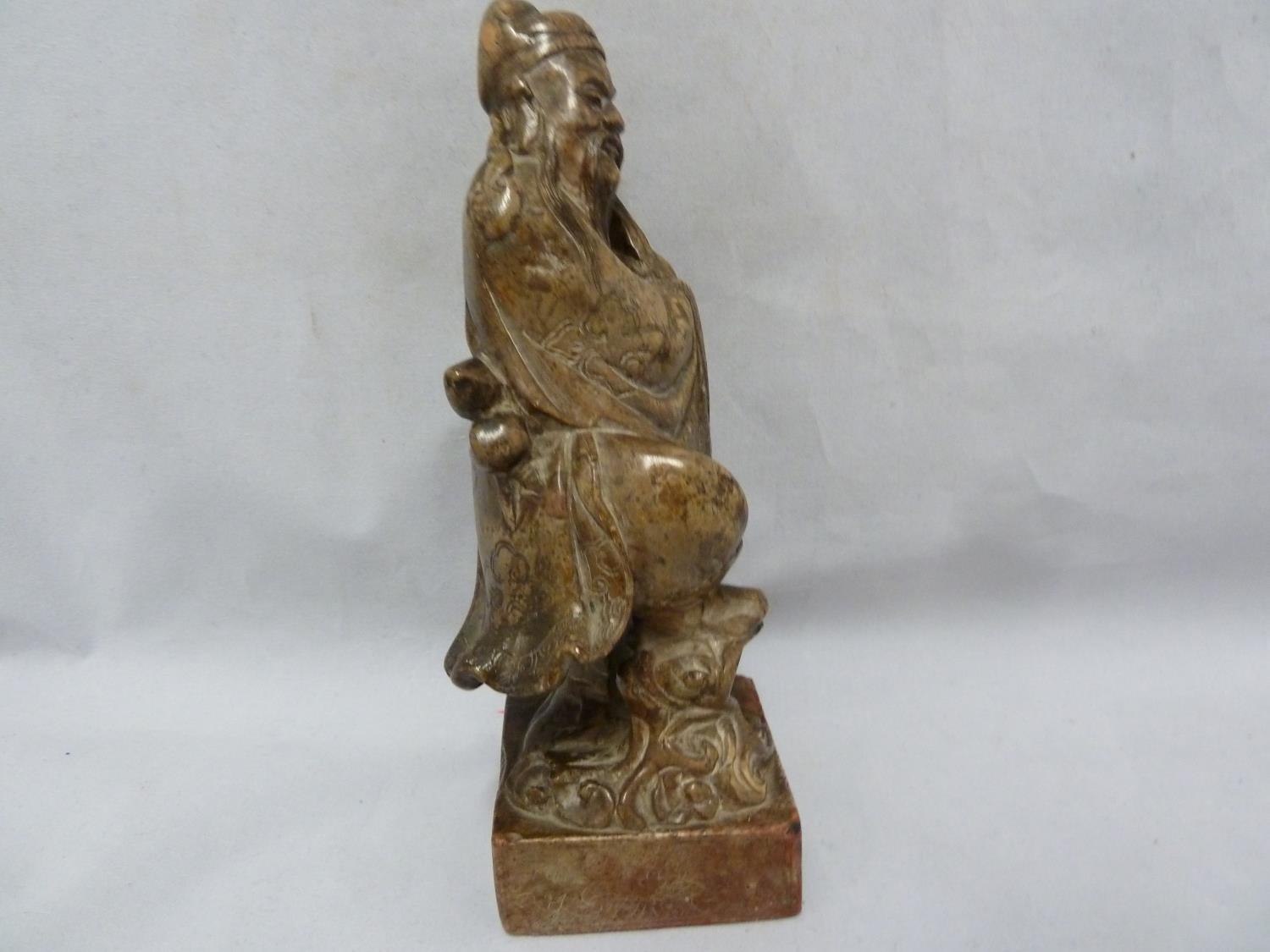 A Chinese carved soapstone figure of an immortal, modelled standing with sceptre and one foot raised - Image 6 of 6