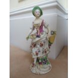 An Early Derby porcelain figure of a fruit seller, she standing with fruit held in her raised