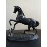 A bronzed metal figure of a prancing horse on oval base, 13cm high max approx