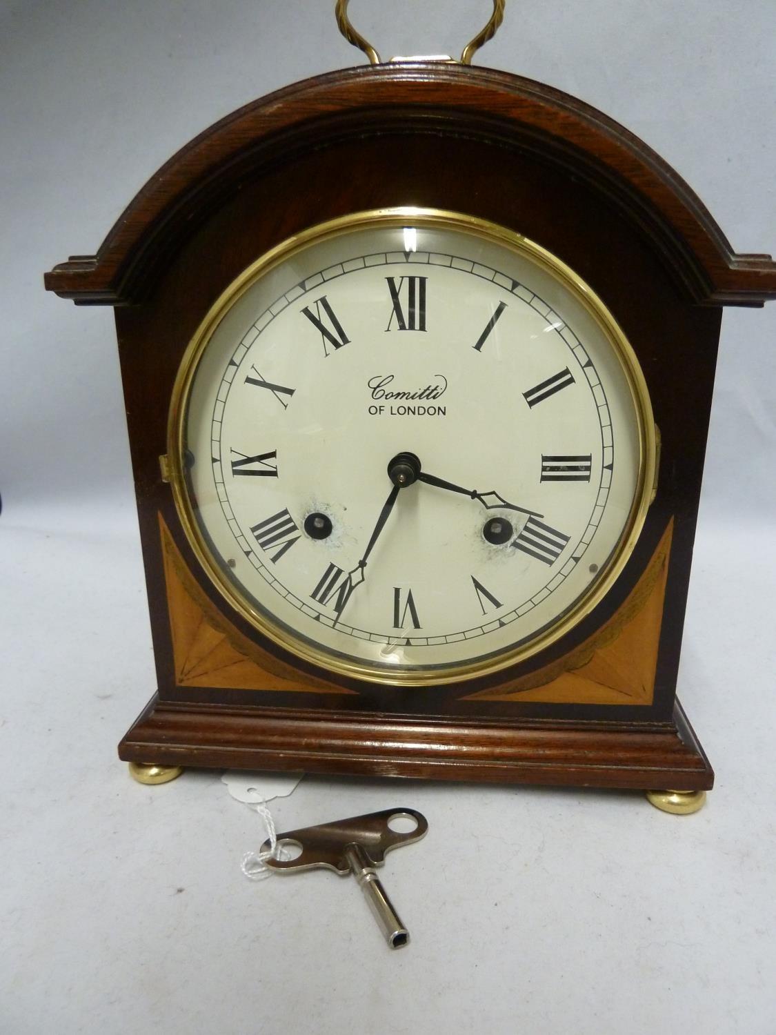 Comitti of London - A Regency style break arch clock, Roman numerals in black on a circluar white