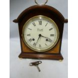 Comitti of London - A Regency style break arch clock, Roman numerals in black on a circluar white