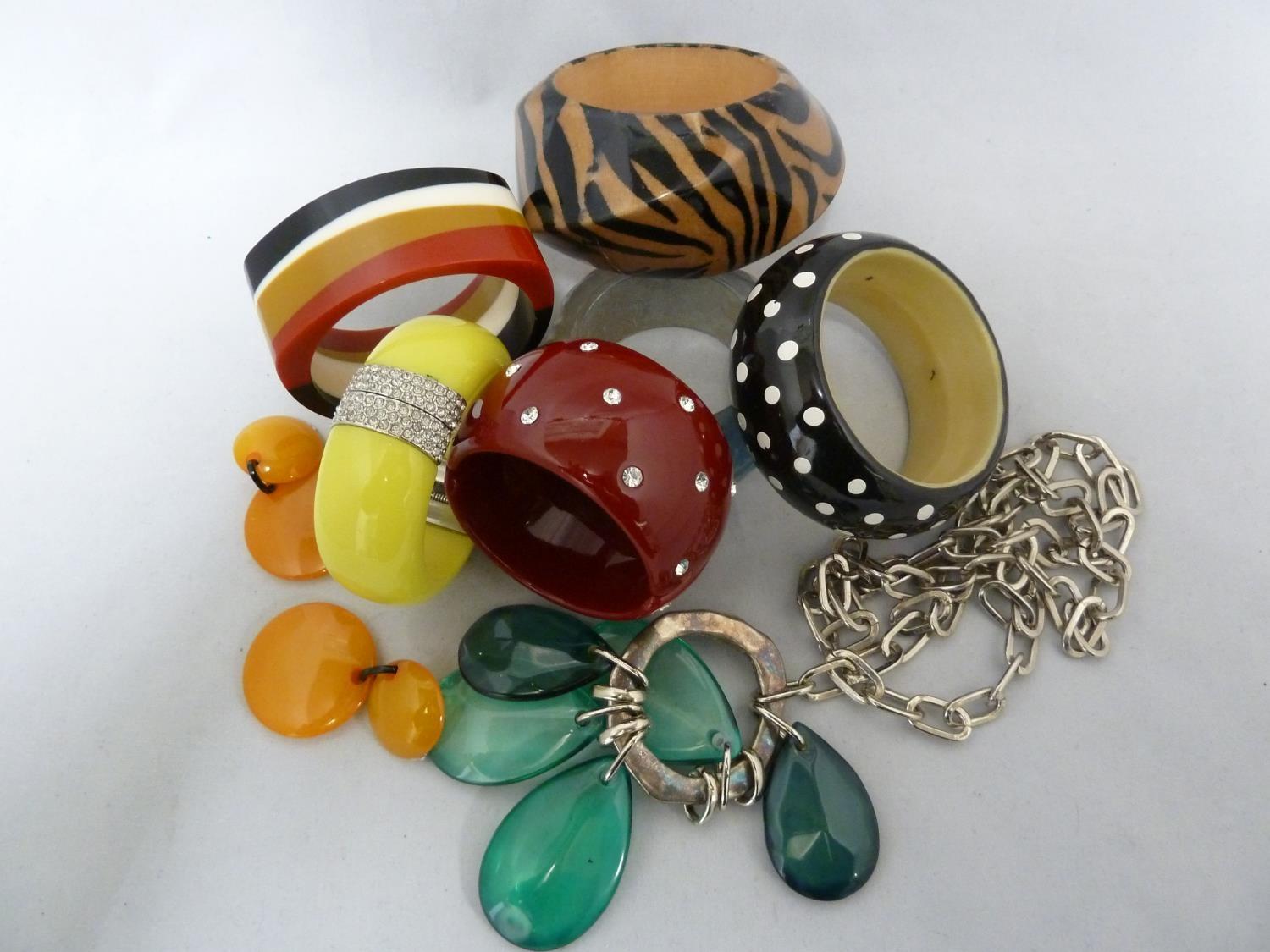 WITHDRAWN - A group of vintage plastic bangles, including a rhinestone spotted example on cherry