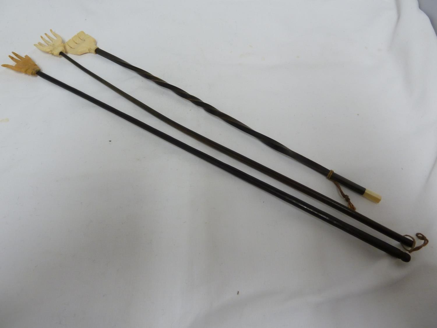 Three bone and turned wood back scratchers, each formed as a hand, 40cm and smaller (3)