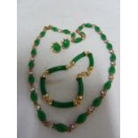 A yellow metal and Jade green hardstone sectional bracelet, the hardstone of curved cylindrical