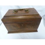 A walnut veneer tea caddy, of stepped sarcoghagus form, boxwood stringing to the corner, the
