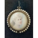 A portrait miniature of a woman, within a circular white metal frame set with half 'pearls',