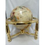 A table top globe, the countries of The World picked out in faux coloured stone and shell on a white