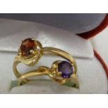 Two rings, each with a garnet or amethyst coloured stone, set in yellow metal marked 375 and 9K,