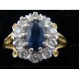 A sapphire and diamond set 18ct yellow gold ring, the oval sapphire encircled by 11 diamonds, ring