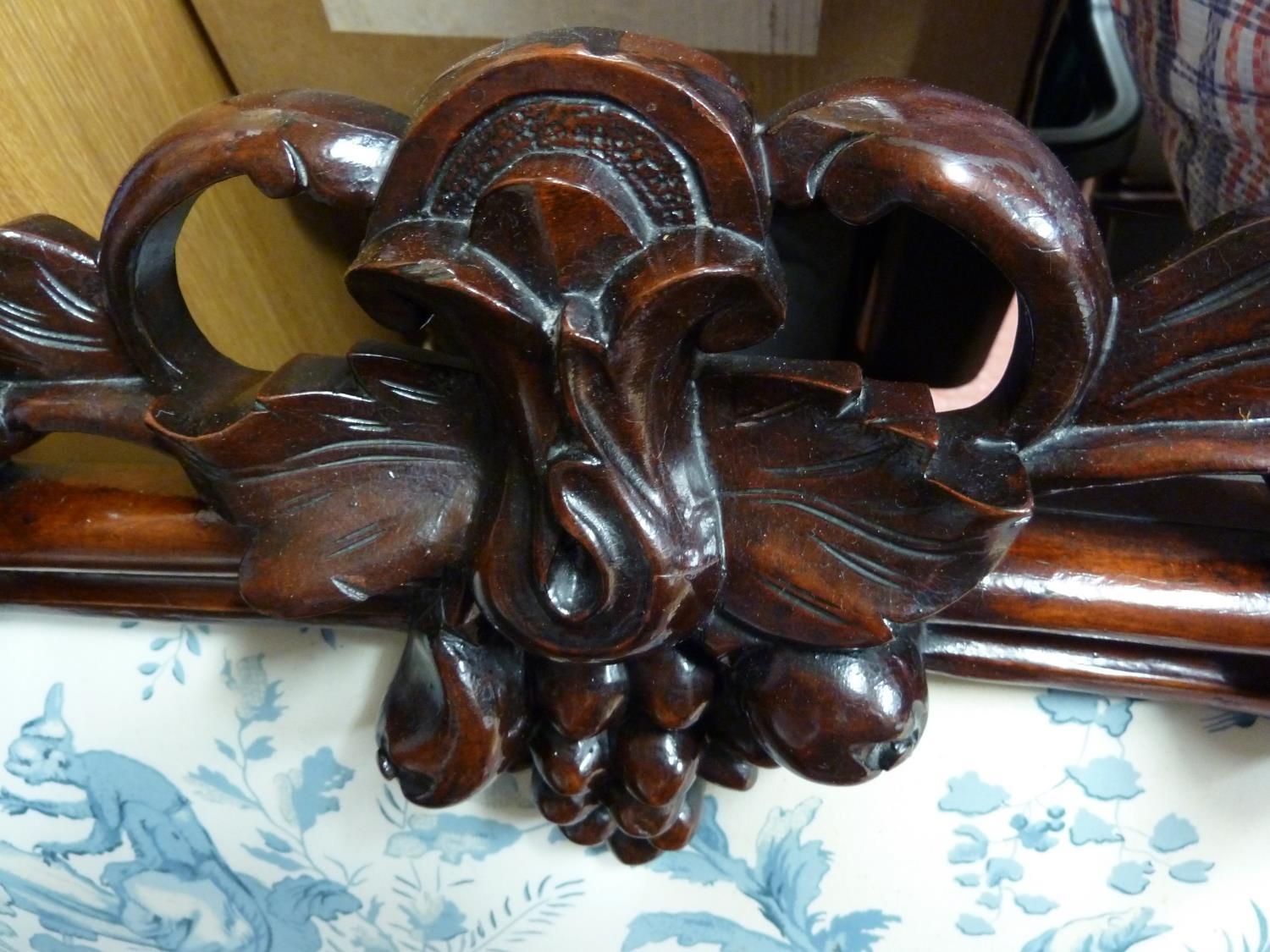 A French mahogany veneered carved wood headboard, decorated with a fruiting vine, upholstered