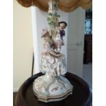 A German porcelain candle stick, probably Meissen, but outside decorated, modeled as a seated